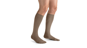 Below knee compression stockings in khaki on both legs