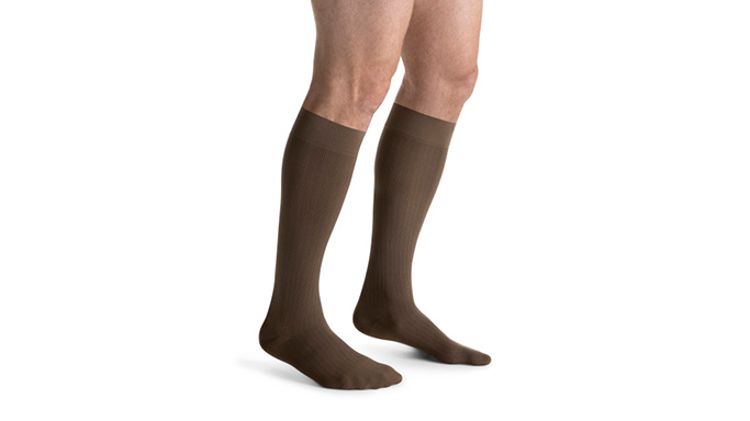 Below knee compression stockings in brown on both legs
